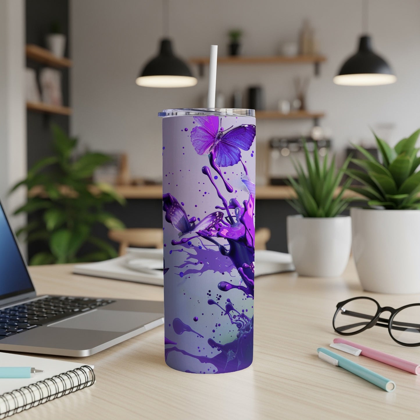 Purple butterfly on a tumbler with paint splatters.