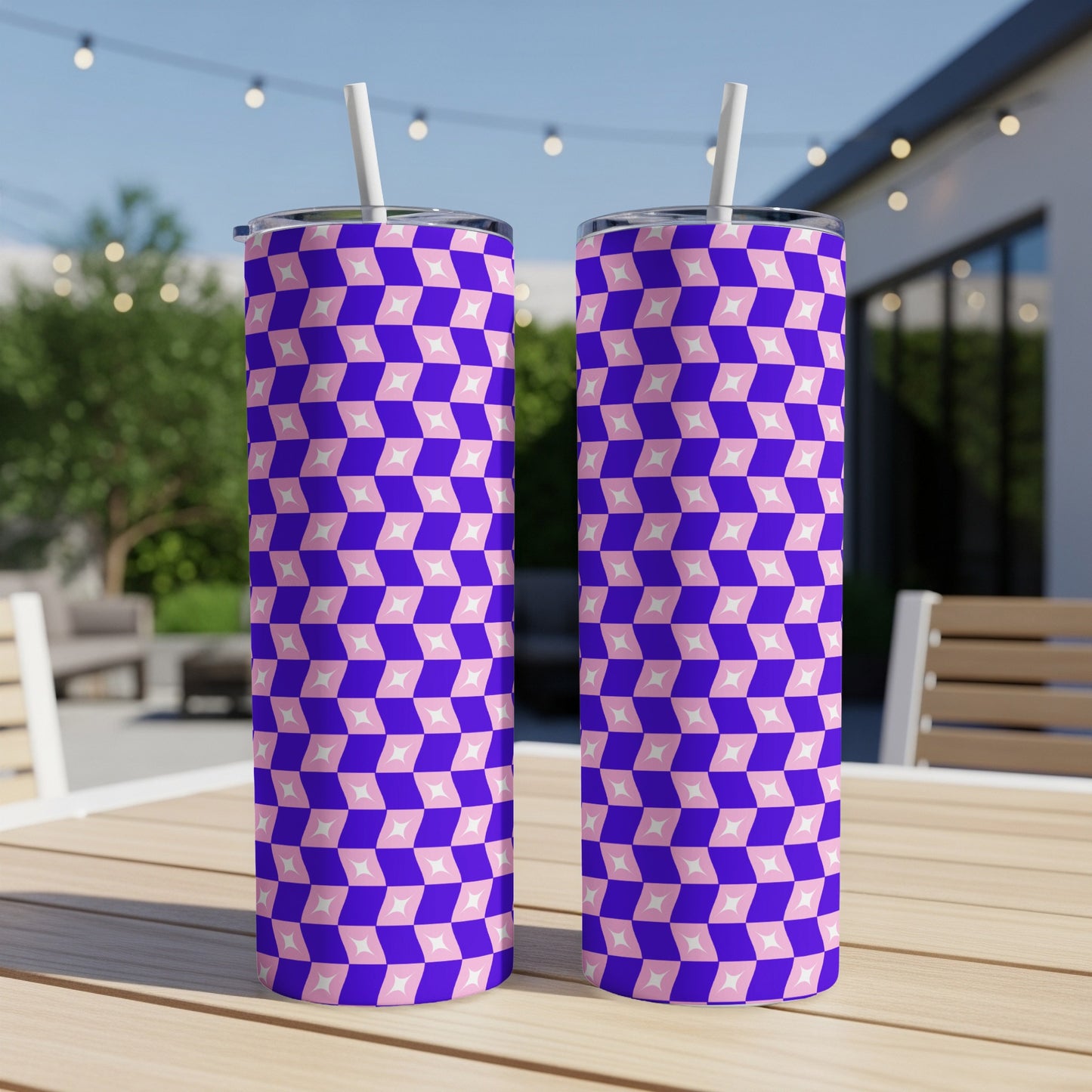 Two tall tumblers with a pink and purple diamond pattern sit on a wooden table.