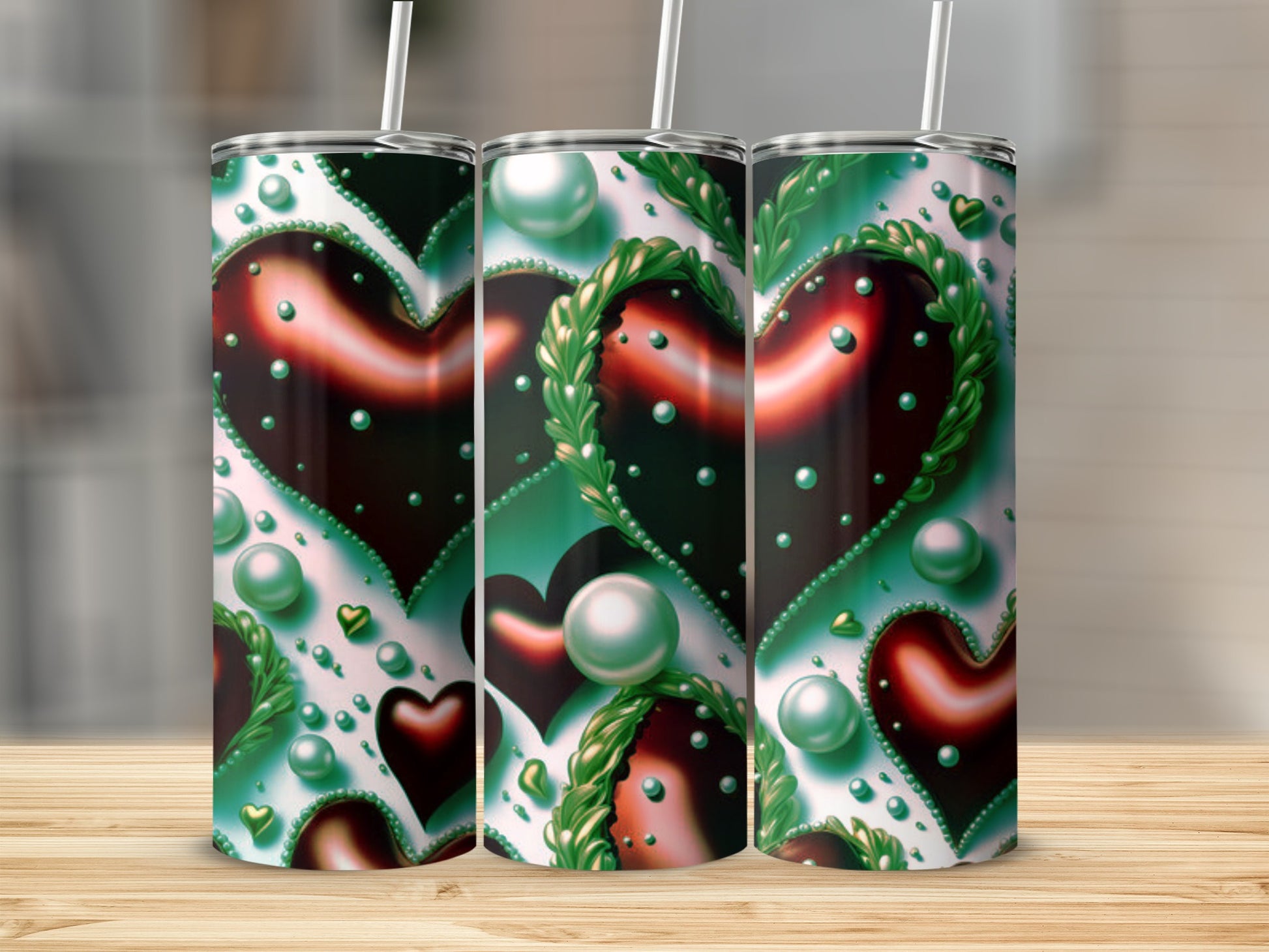 Three tumblers with heart and pearl designs on a wooden surface.