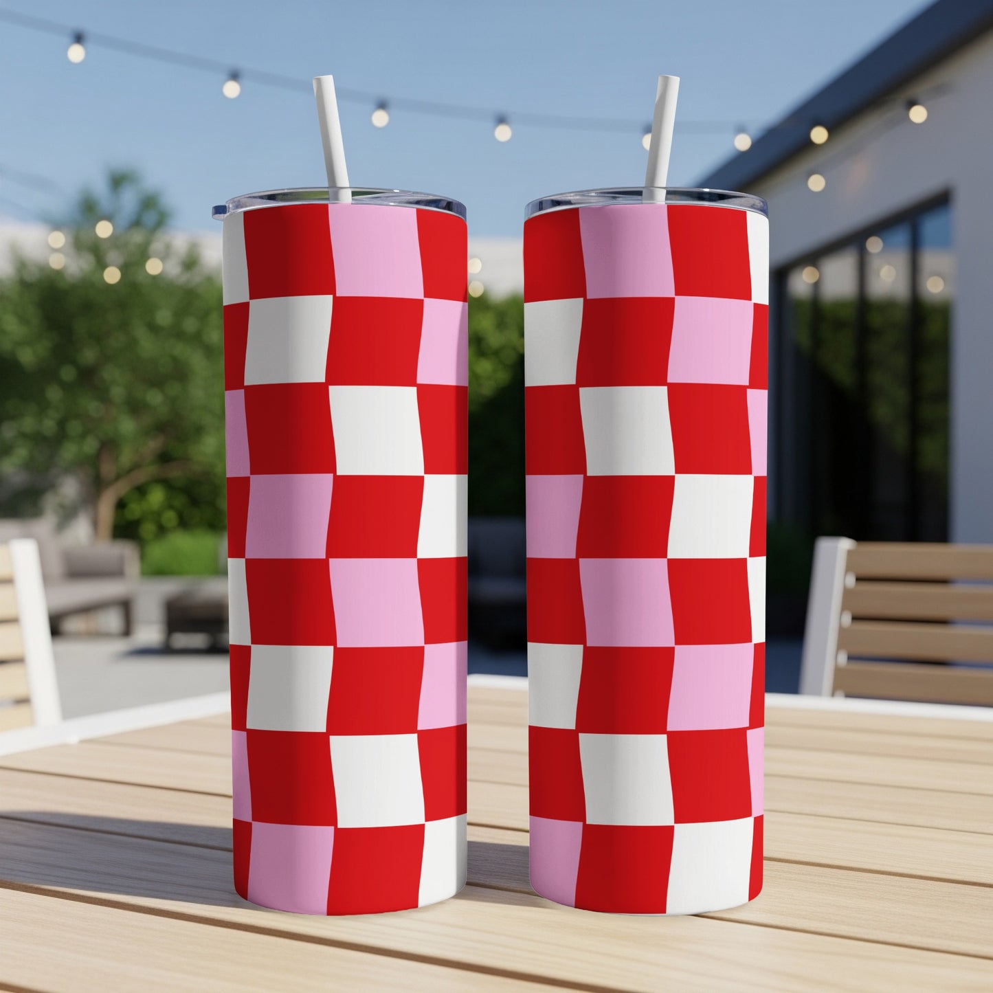 Two tall tumblers with a red and pink checkerboard pattern and white straws.