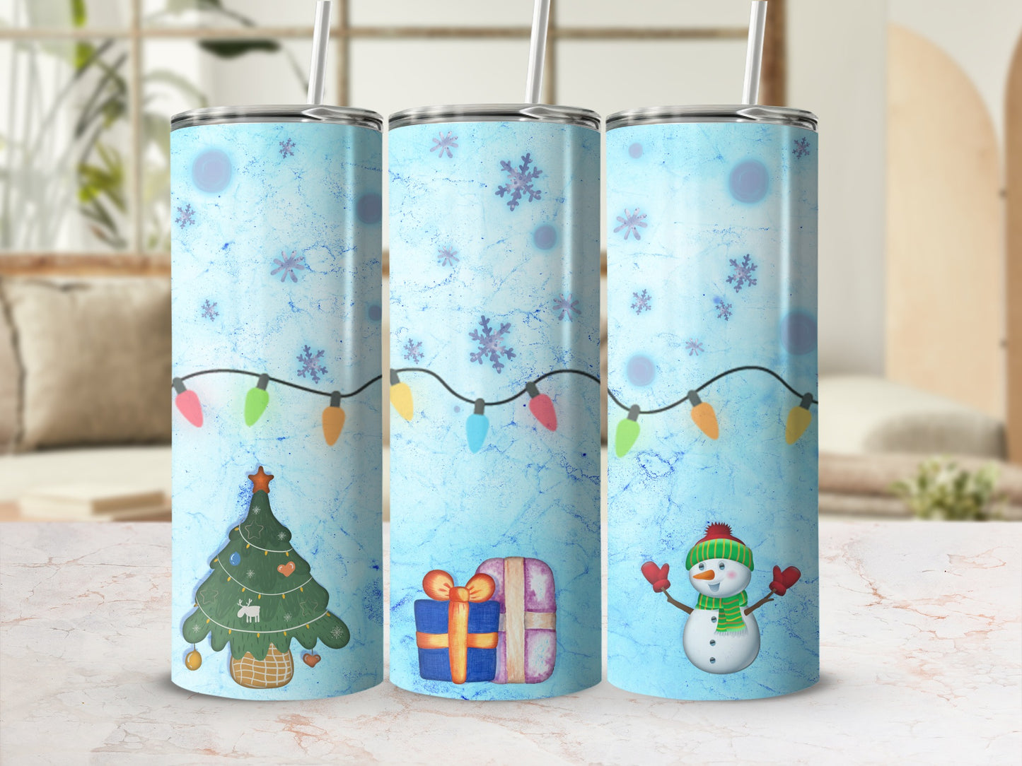 Three tumblers with Christmas graphics: tree, gift, and snowman on blue background.