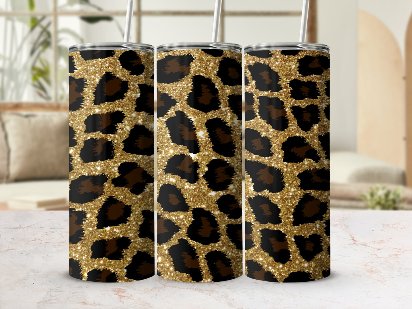 Three tumblers with a gold glitter leopard print design and silver straws.