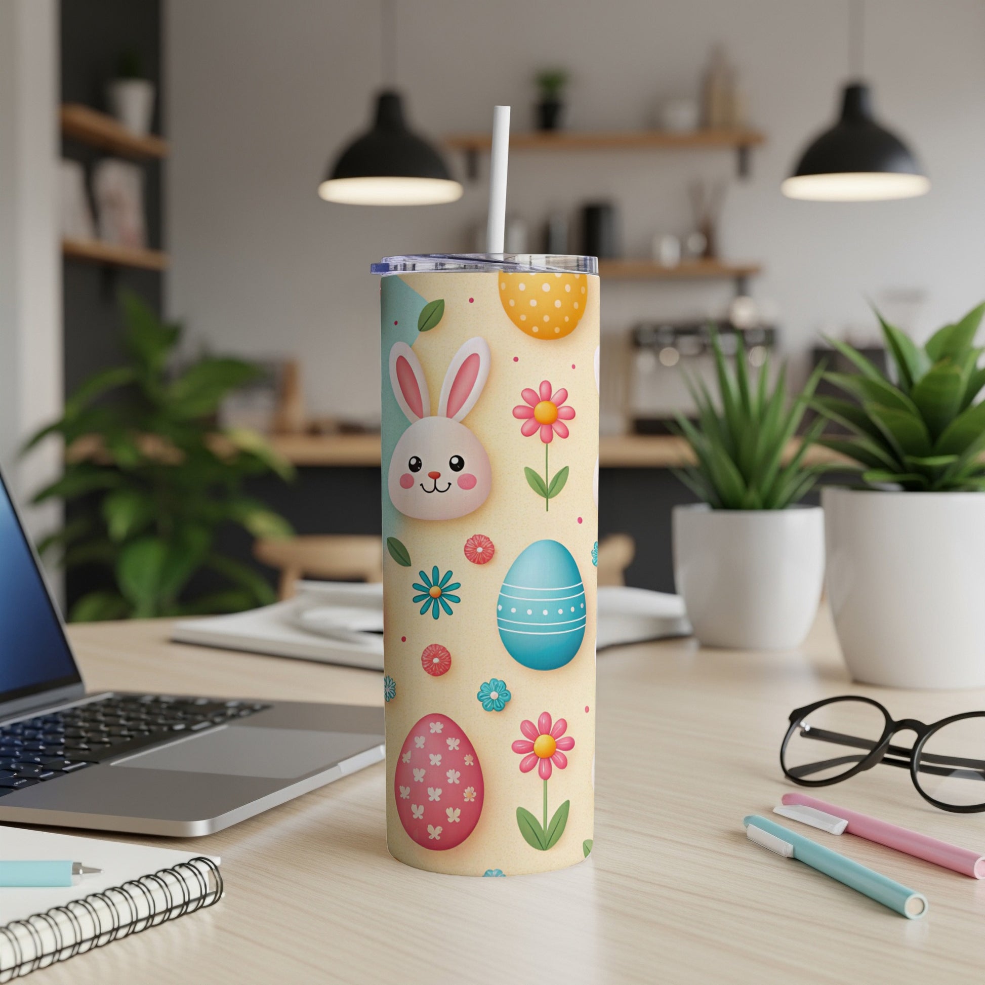 Easter tumbler with bunnies, eggs, and flowers on a desk.