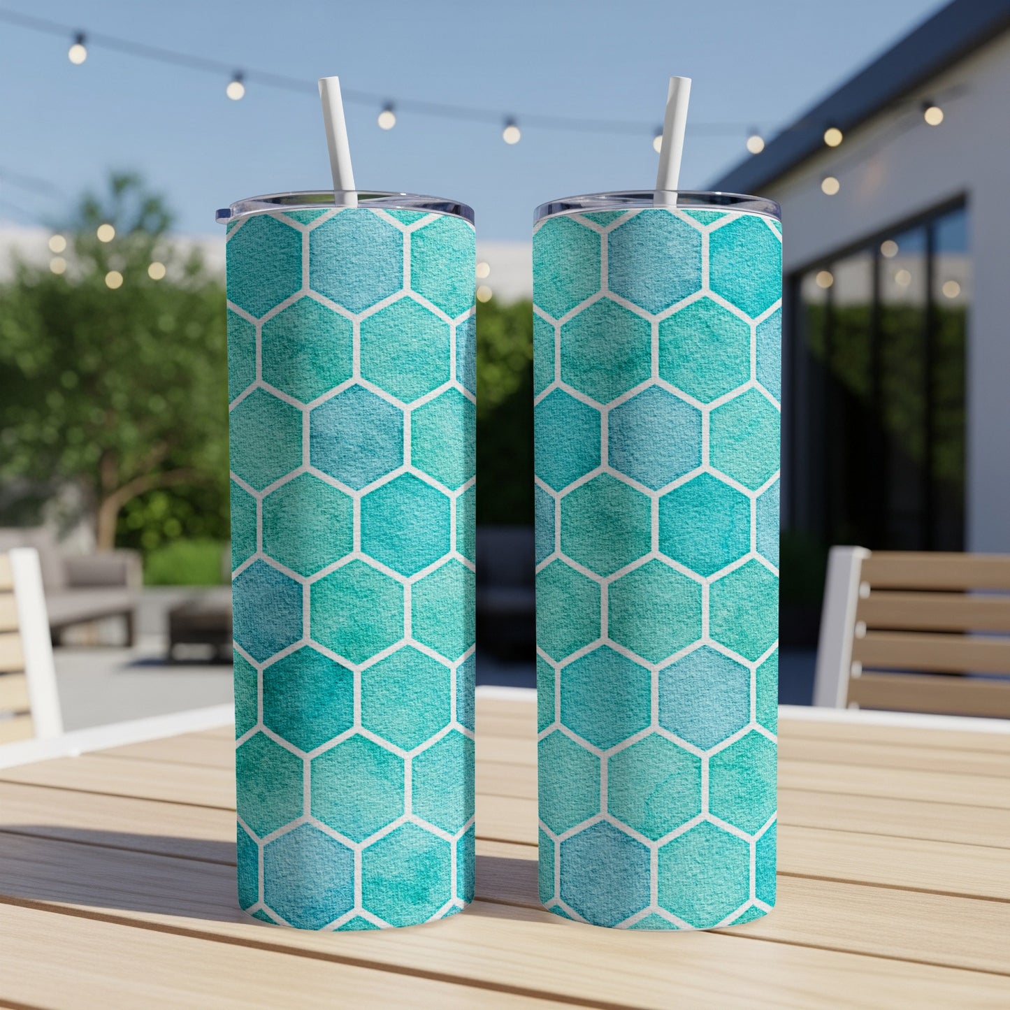 Two tall tumblers with a teal honeycomb pattern sit on a wooden table.
