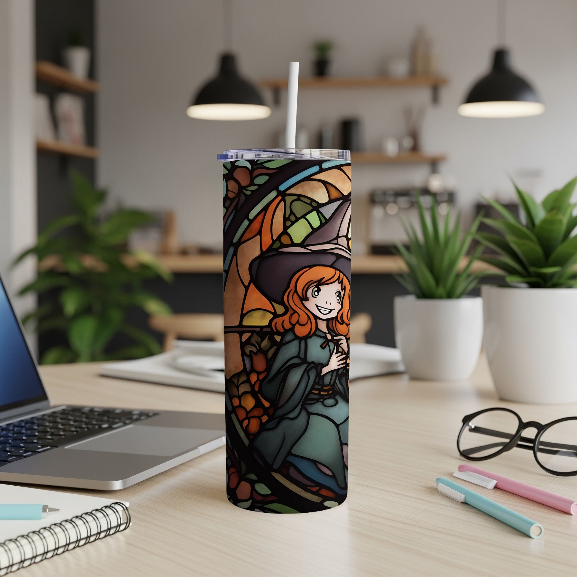 Stained glass tumbler featuring a smiling witch in an orange hat and green dress.