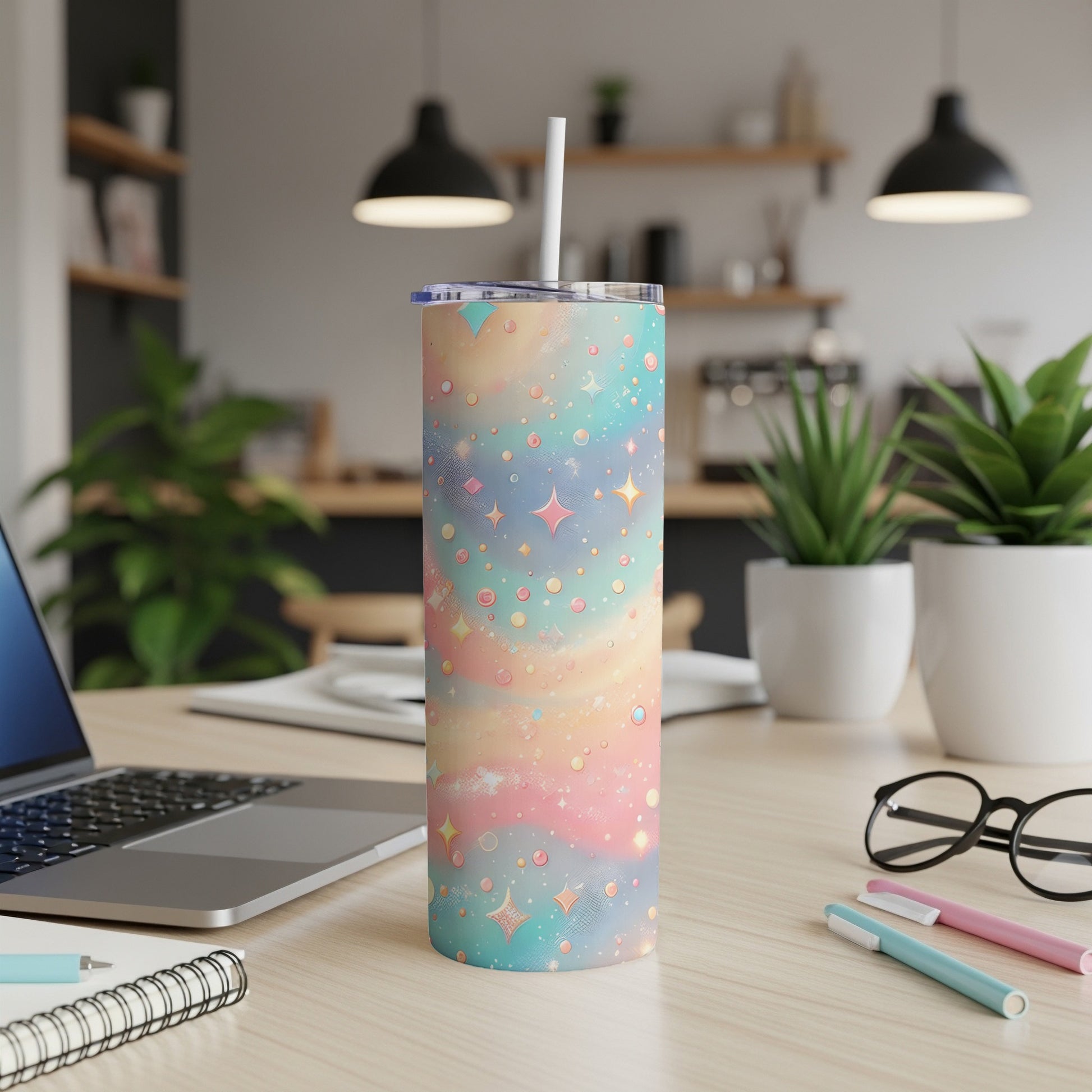 Pastel starry sky tumbler with straw on a desk with laptop.