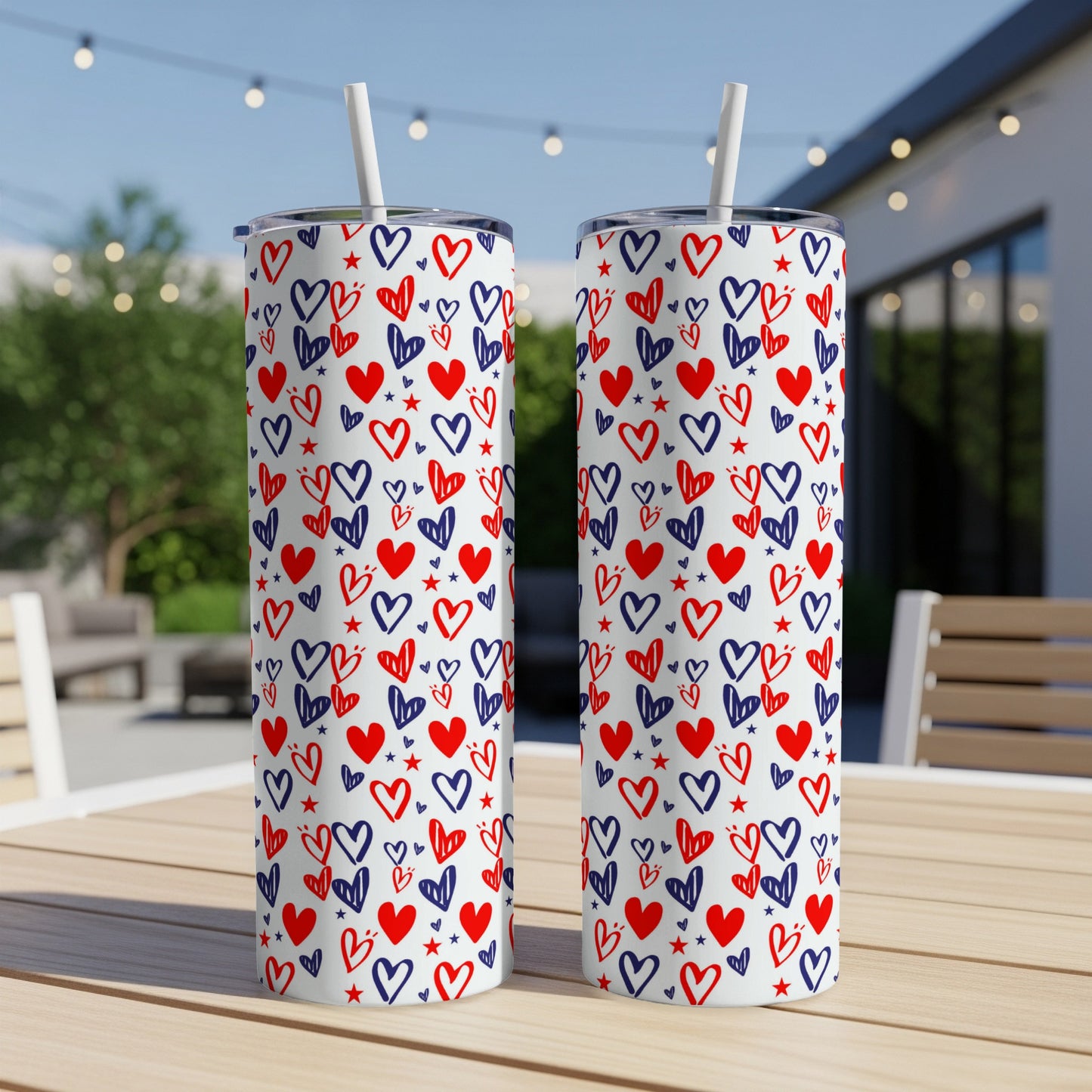 Two white tumblers with red and blue heart and star pattern on a wooden table.
