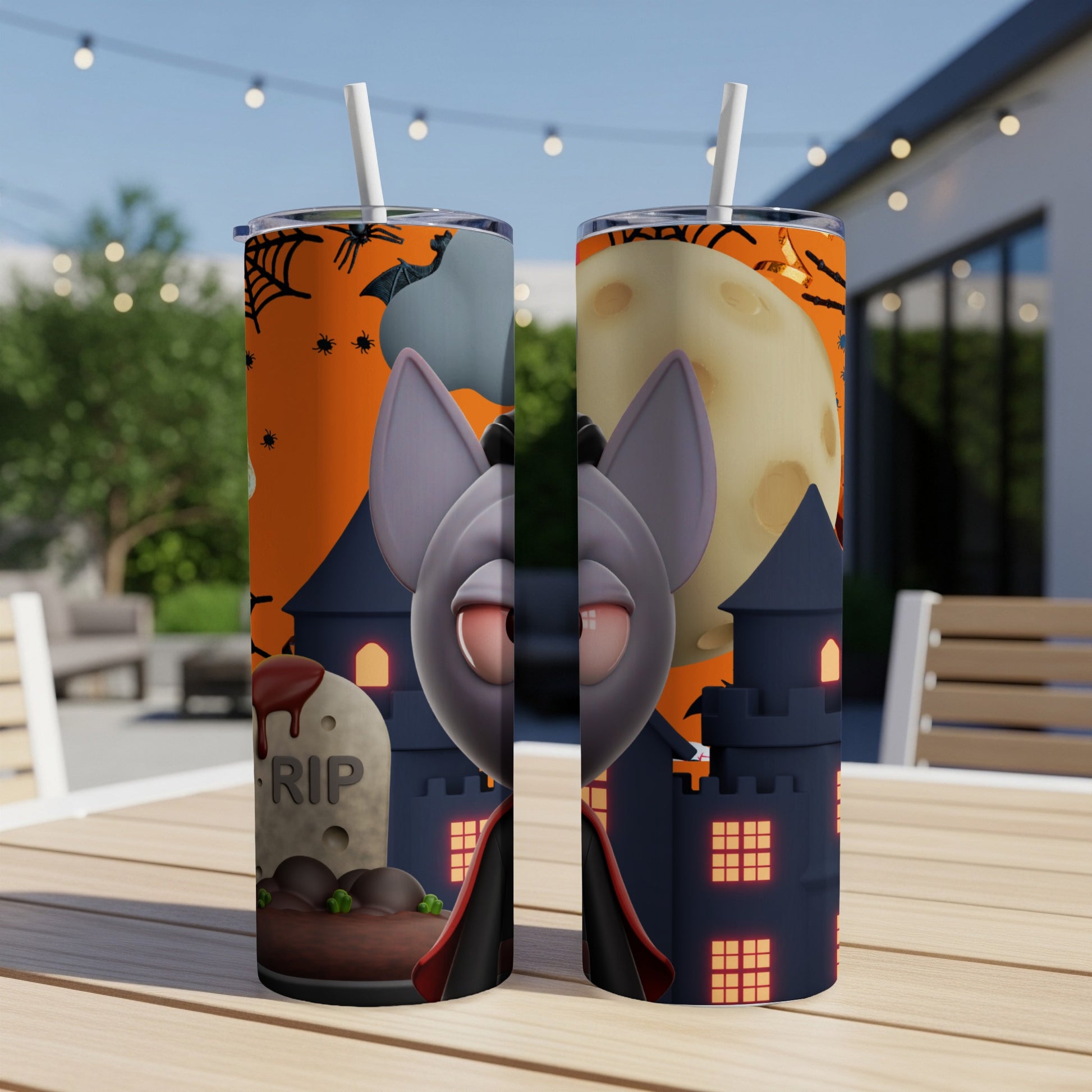 Two tumblers with Halloween design featuring a cartoon bat, tombstone, and castle.