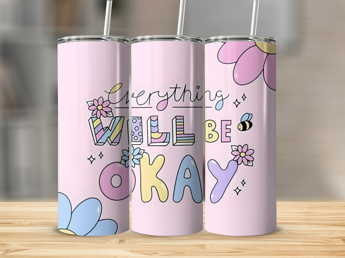 Pink tumbler with "Everything Will Be Okay" text and floral designs.