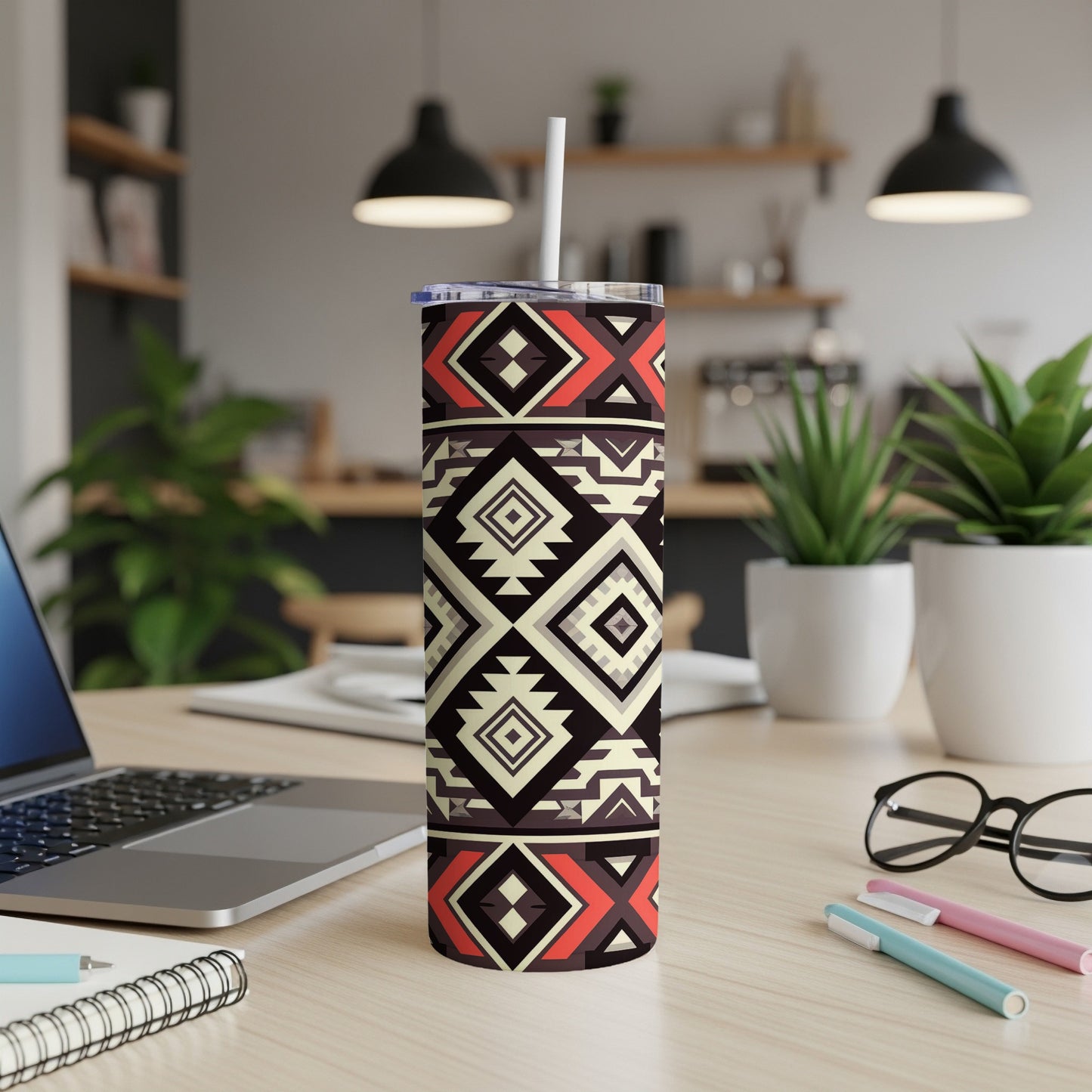 Tribal pattern tumbler with straw on a desk with a laptop and pens.