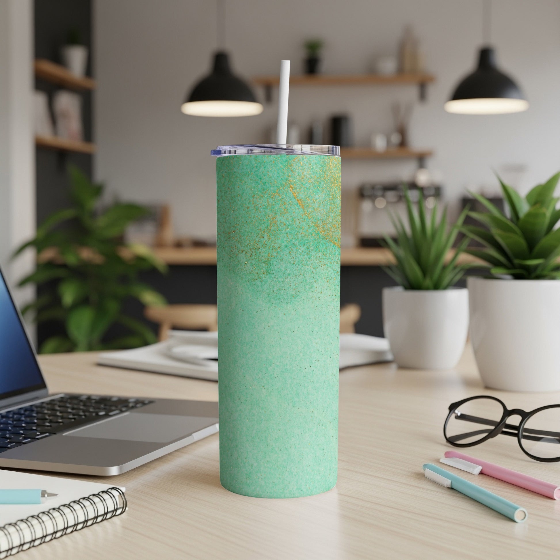 Green glitter tumbler with a white straw on a desk.