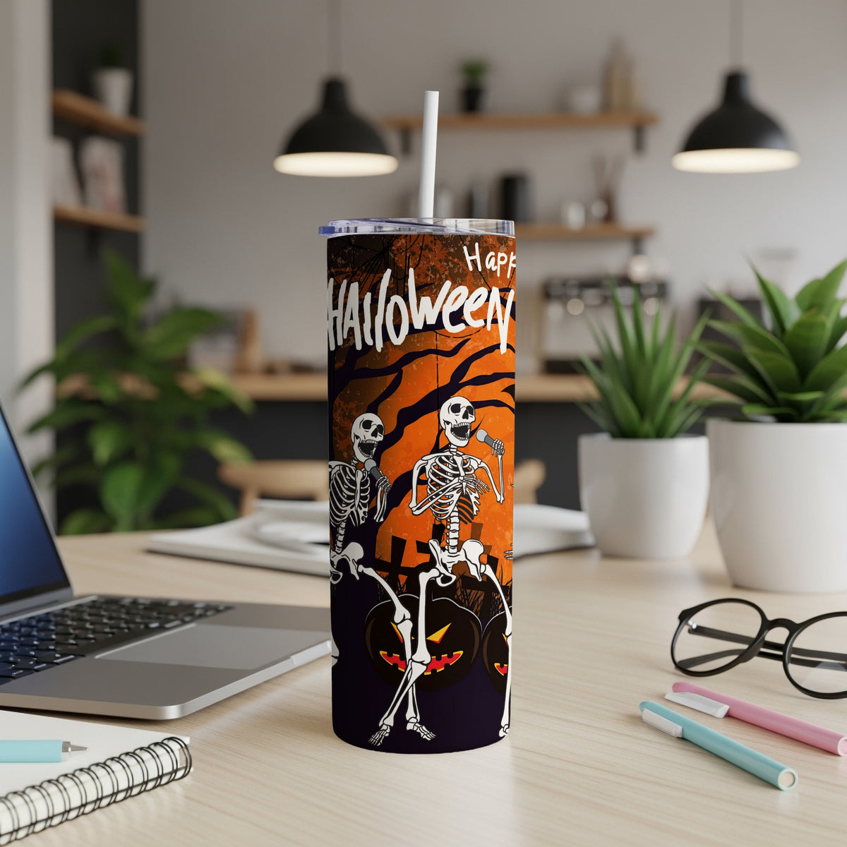 Halloween tumbler with skeletons singing and pumpkins on an orange and black background.