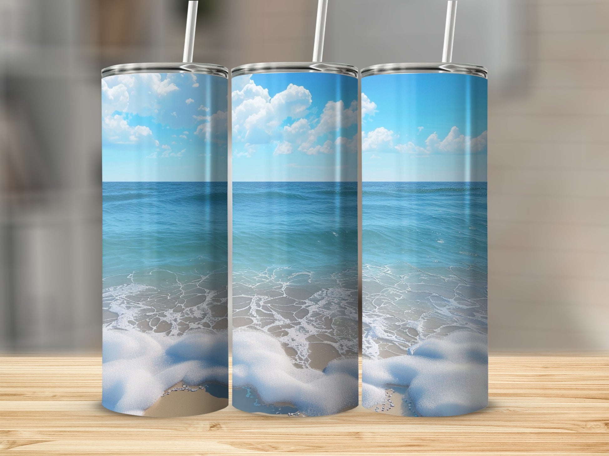 Three tumblers featuring a beach scene with ocean waves and clouds.