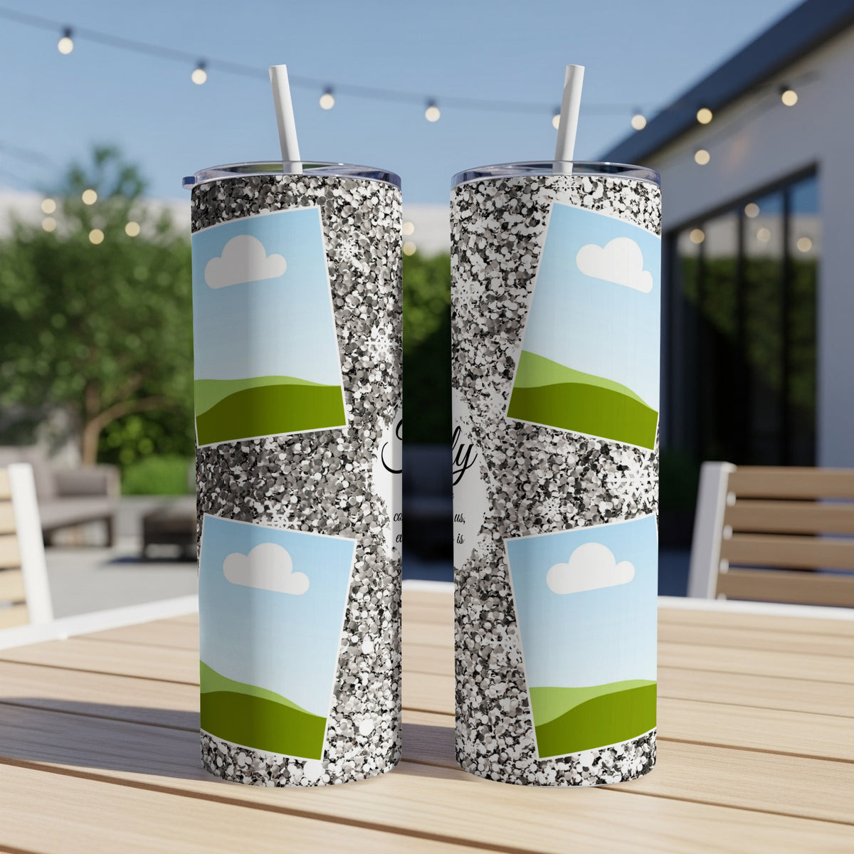 Two glitter tumblers with photo frames of clouds and green hills.