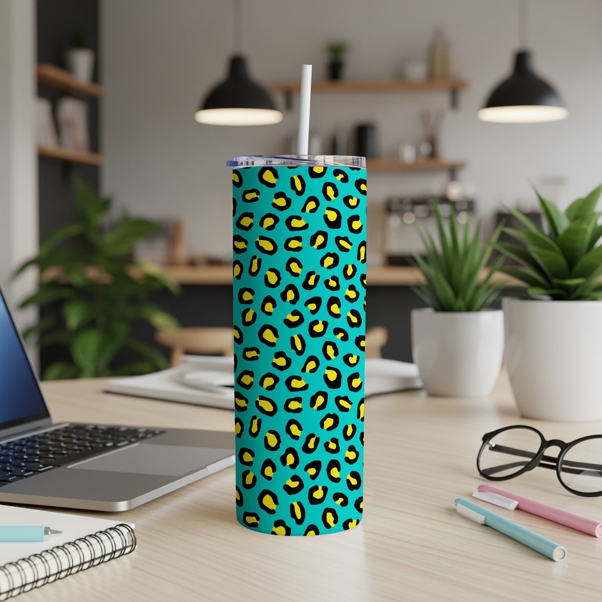 Teal tumbler with yellow and black leopard print and white straw.
