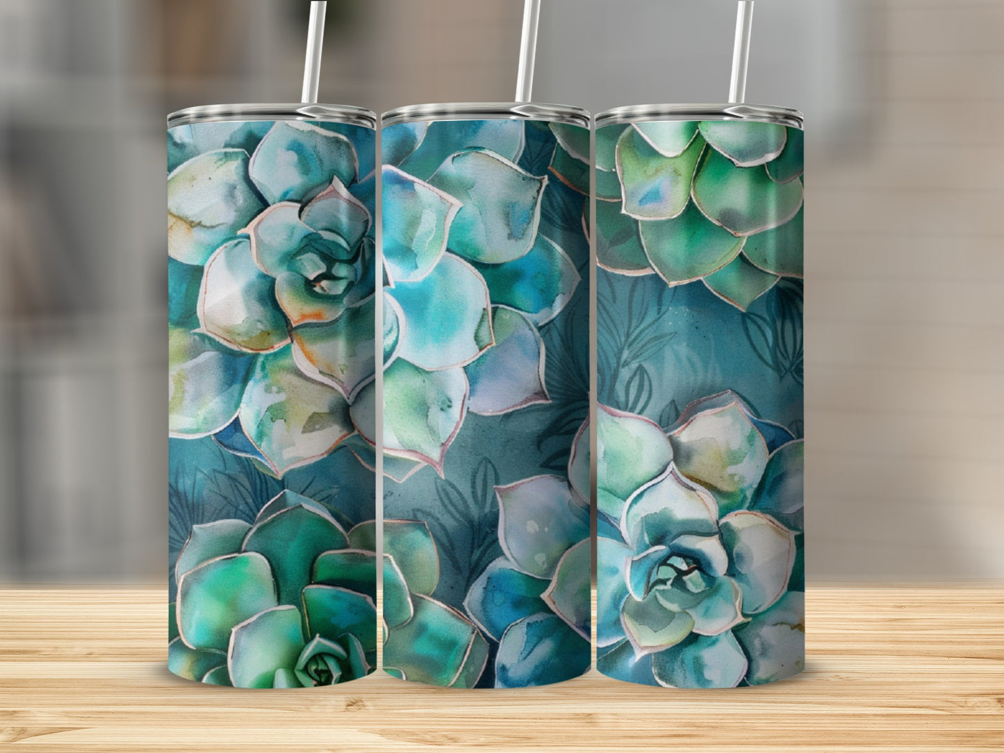 Three tumblers with watercolor succulent floral designs on a wooden surface.