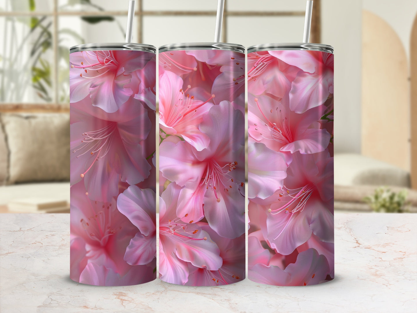 Three tumblers with pink floral pattern on a marble surface.