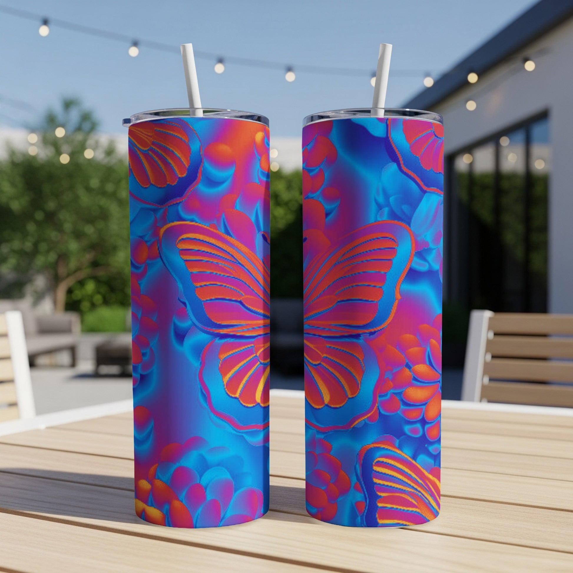 Two tall, colorful tumblers with butterfly and floral designs on a table.