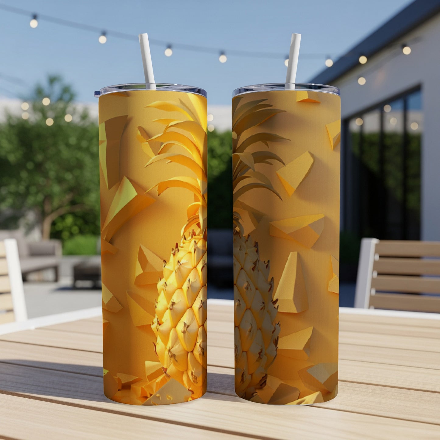 Two golden pineapple tumblers with straws on a wooden table.