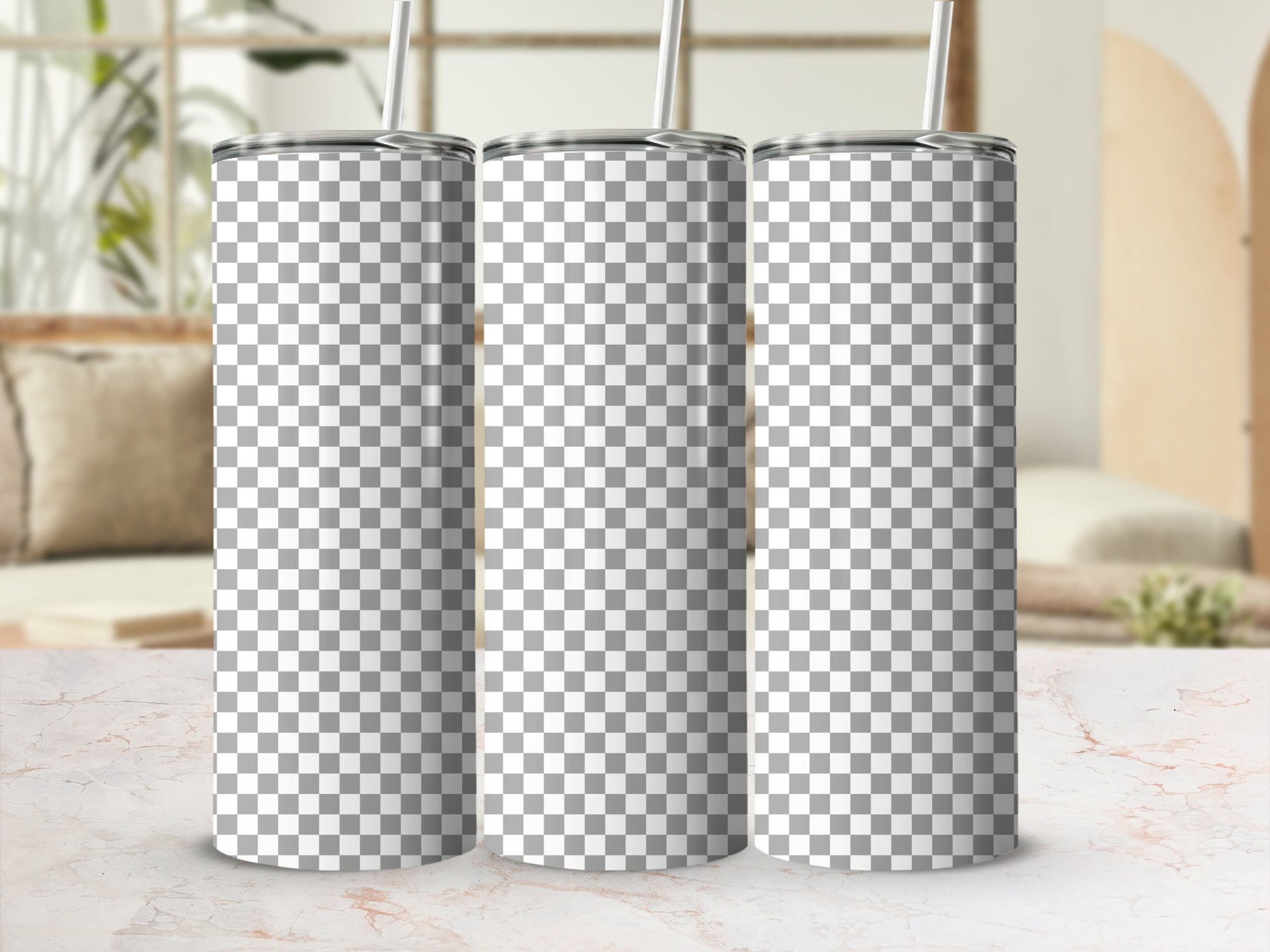 Three blank checkered tumblers with straws on a marble surface.