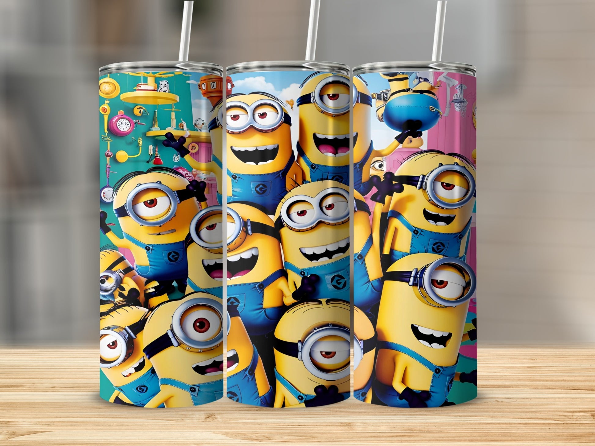 Three Minion character tumblers with straws arranged on a wooden surface.