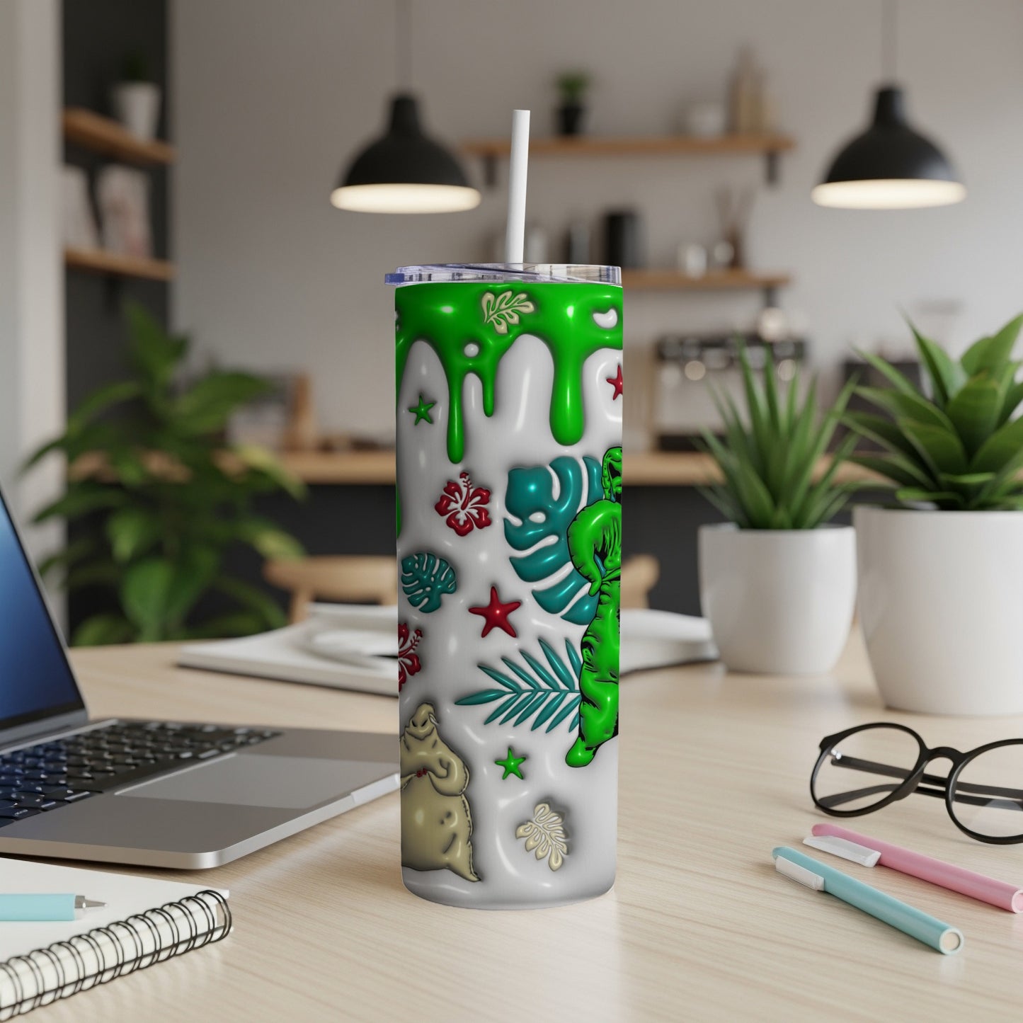 White tumbler with green alien, ghosts, and tropical leaves.