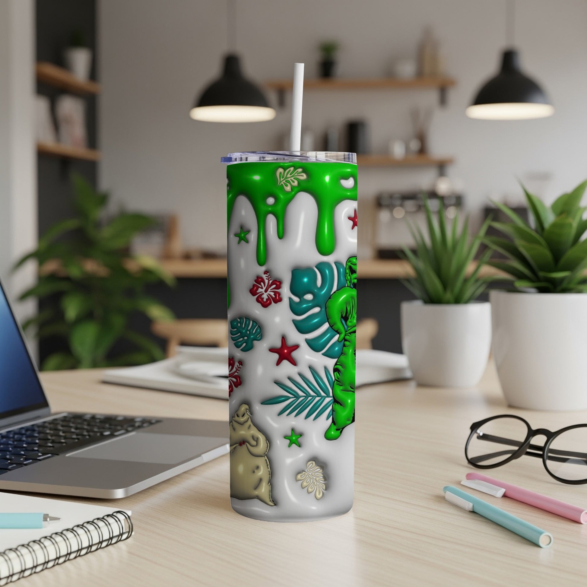 White tumbler with green alien, ghosts, and tropical leaves.