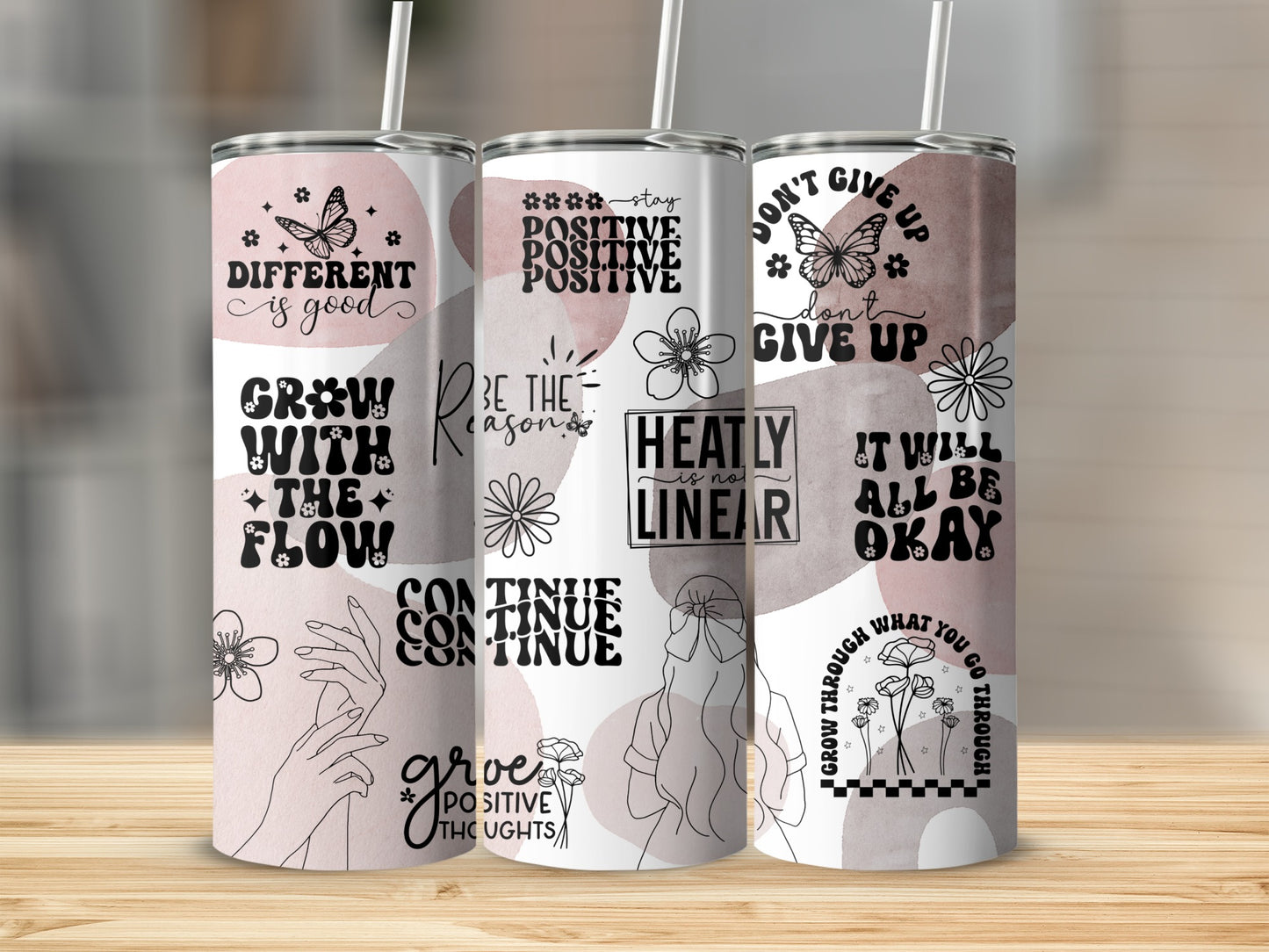 Three tumblers with inspirational quotes and floral designs.