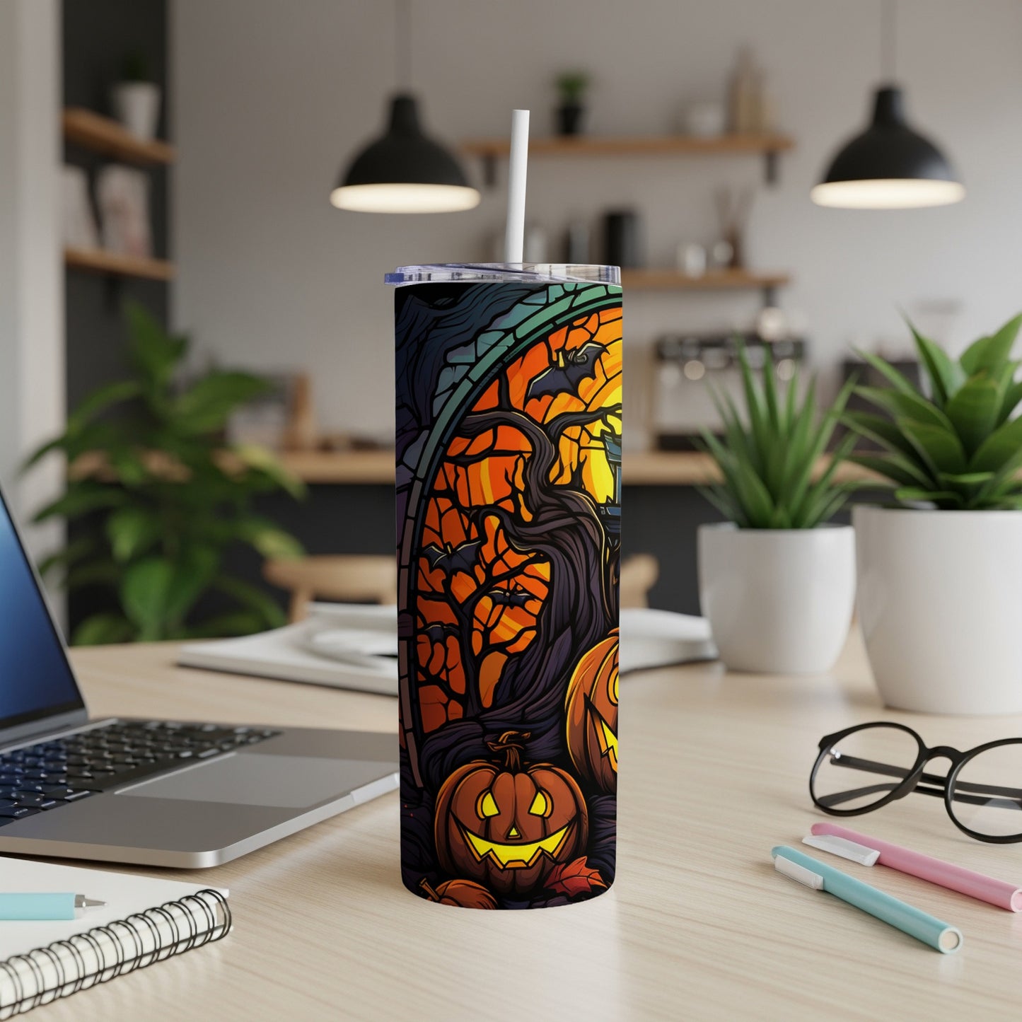 Halloween tumbler with pumpkins, bats, and spooky trees against an orange sky.