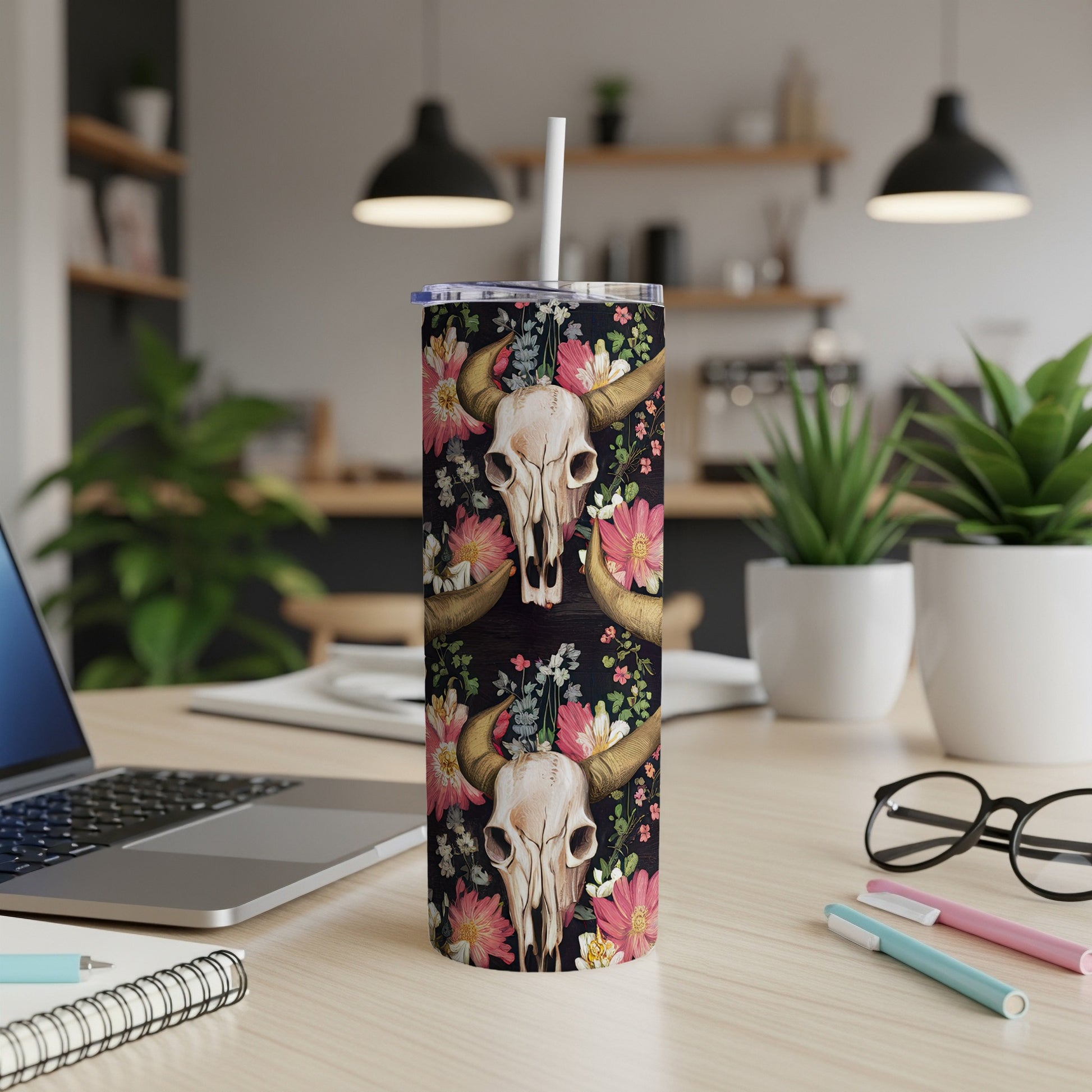 Tumbler with cow skull and floral pattern on wooden background.