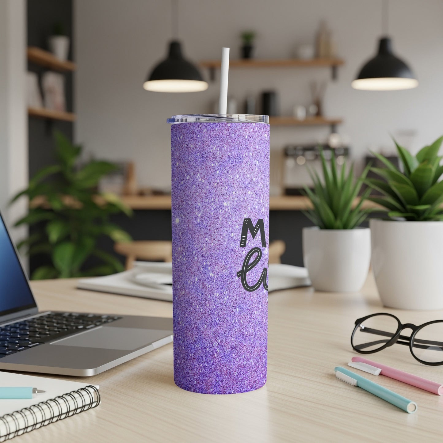 Sparkling purple tumbler with "Mom life" text on a desk.