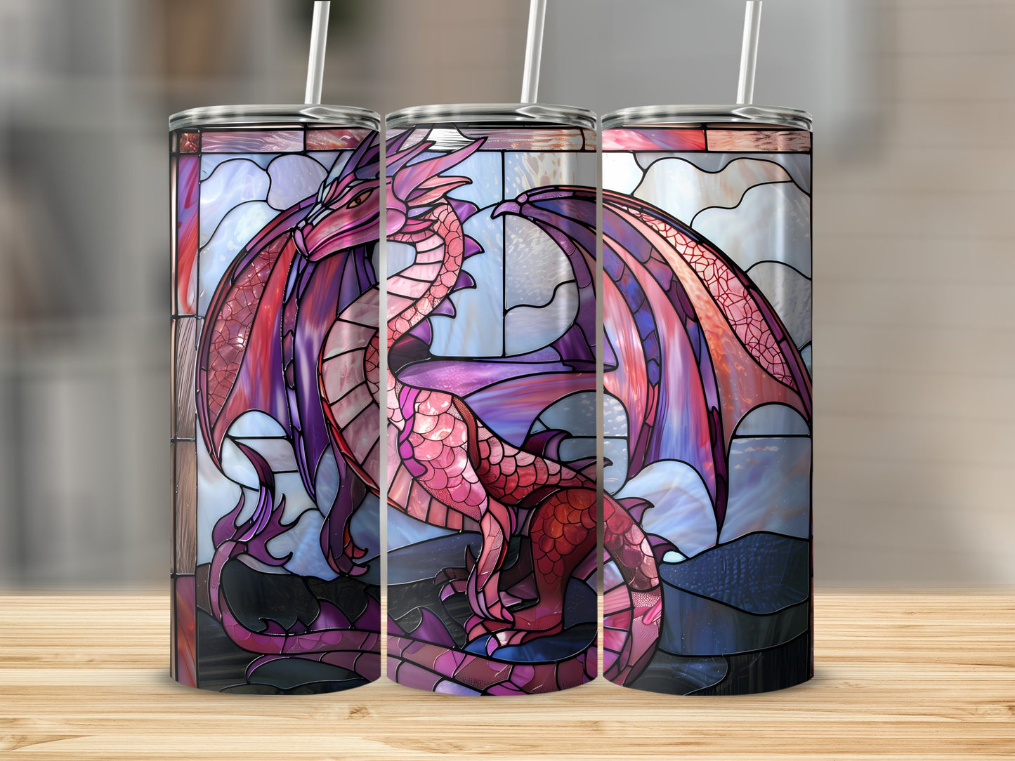 Dragon stained glass design on three tumblers on a wooden surface.