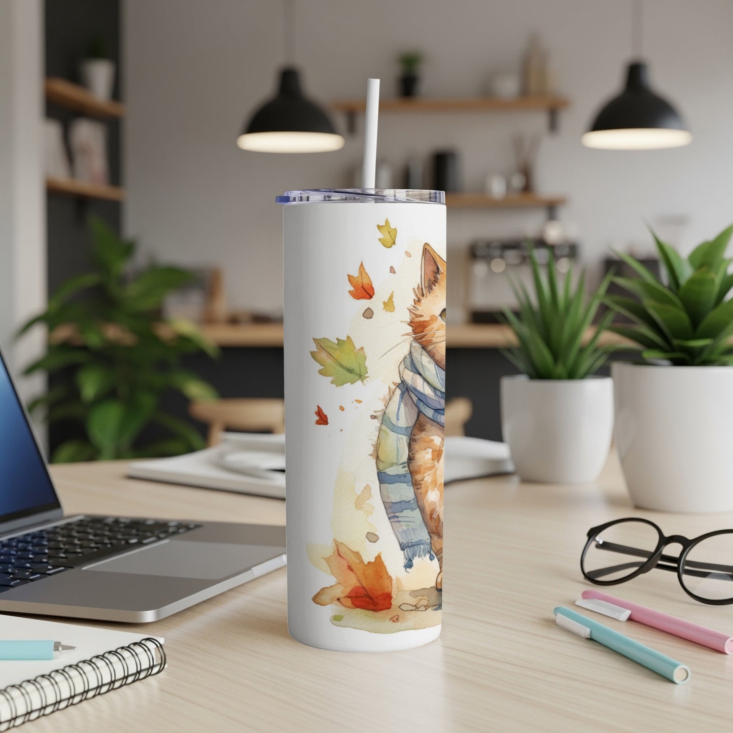Watercolor cat wearing a scarf among autumn leaves on a white tumbler.