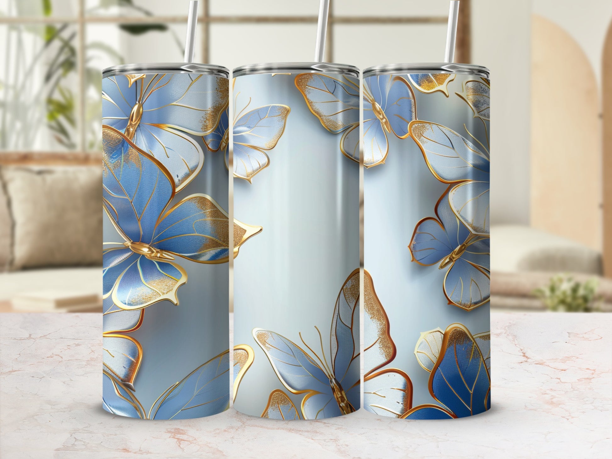Three blue butterfly tumblers with gold accents on a light marble surface.