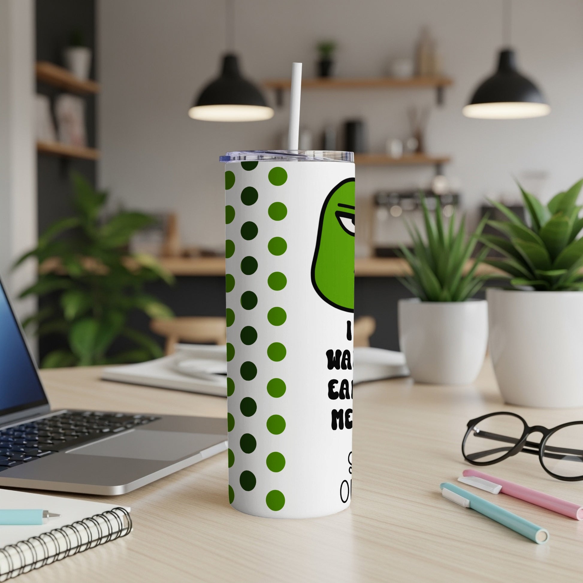 White tumbler with green polka dots and a cartoon frog face saying "I want cake".