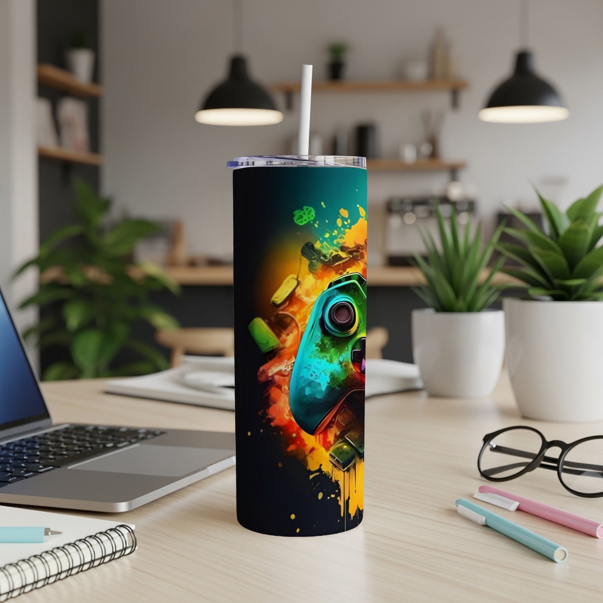Gaming controller on a dark tumbler with colorful abstract paint splatter.