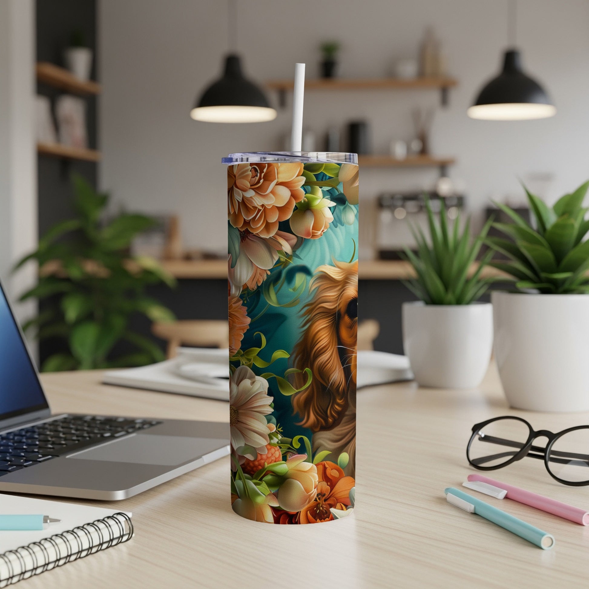 Floral tumbler featuring a dog's face on a desk with a laptop.