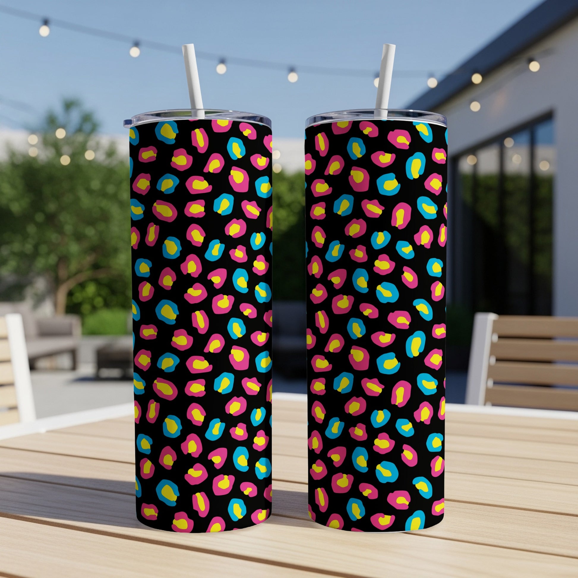 Two tumblers with a black background and brightly colored leopard print in hot pink, yellow, and teal.