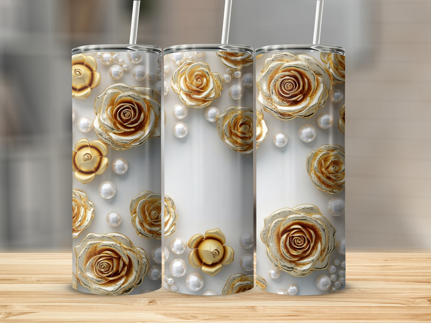 Three tall tumblers with a gold rose and pearl design on a wooden surface.