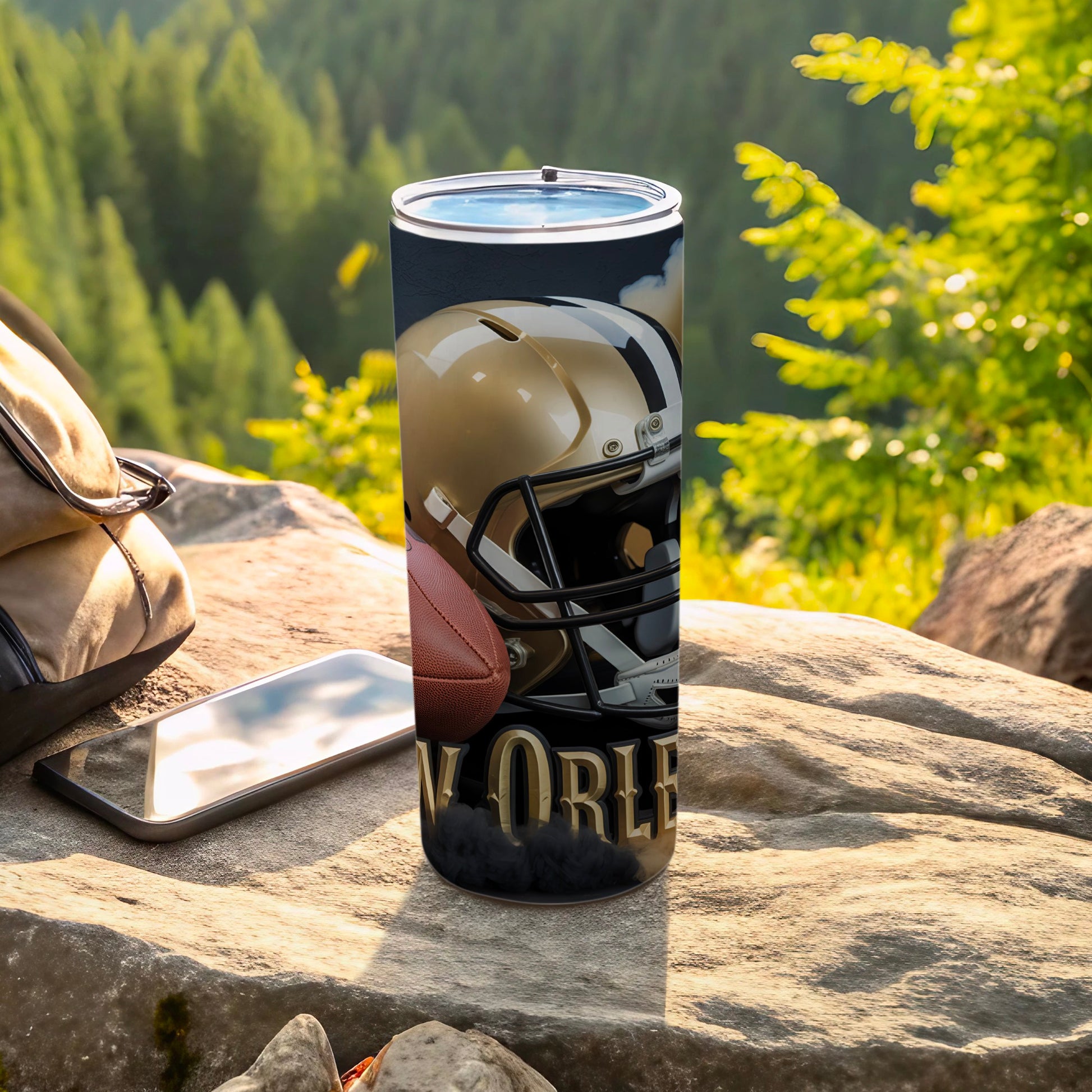 New Orleans Saints helmet and football on rocks, with phone and bag.