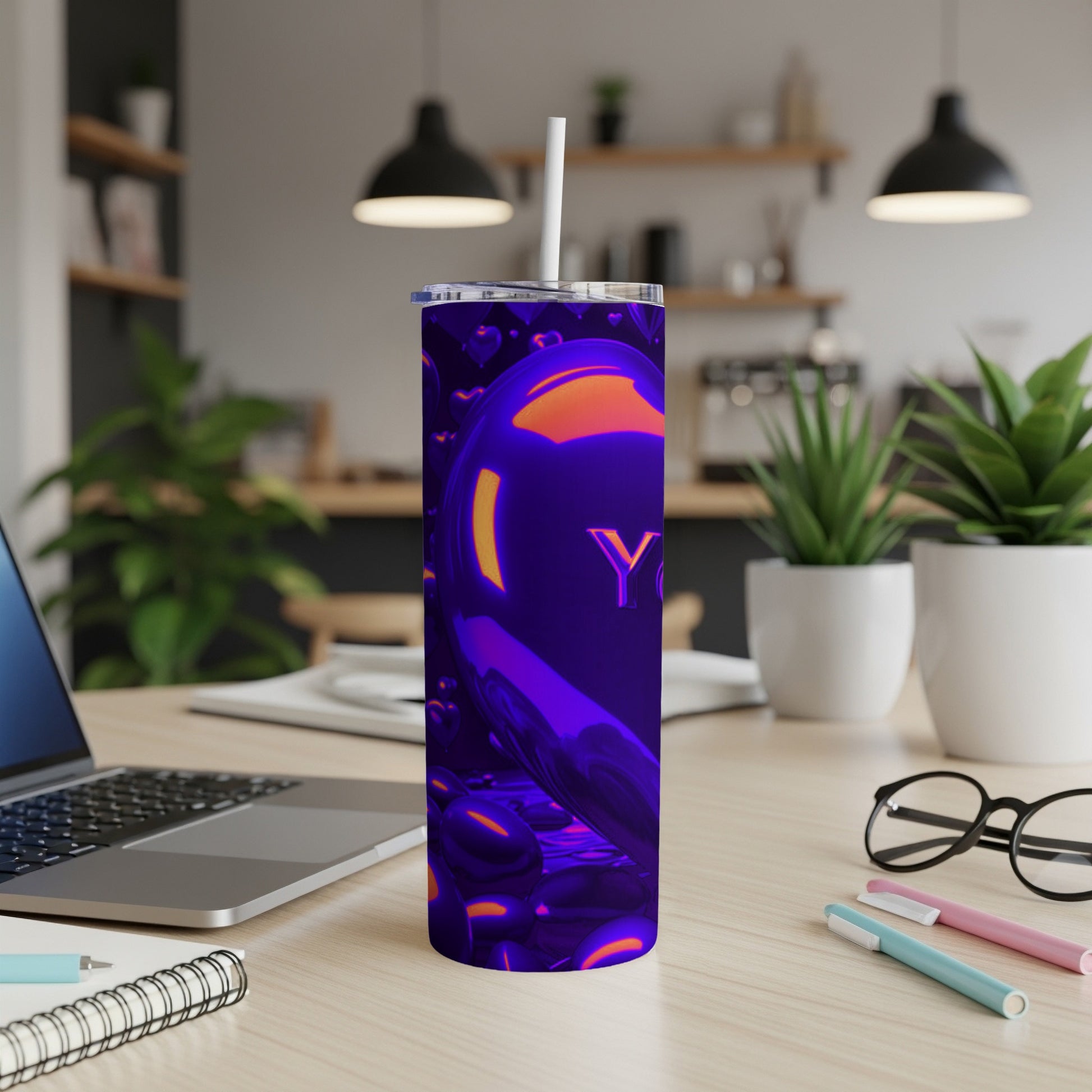Purple metallic tumbler with hearts and "YOU" text on a desk.