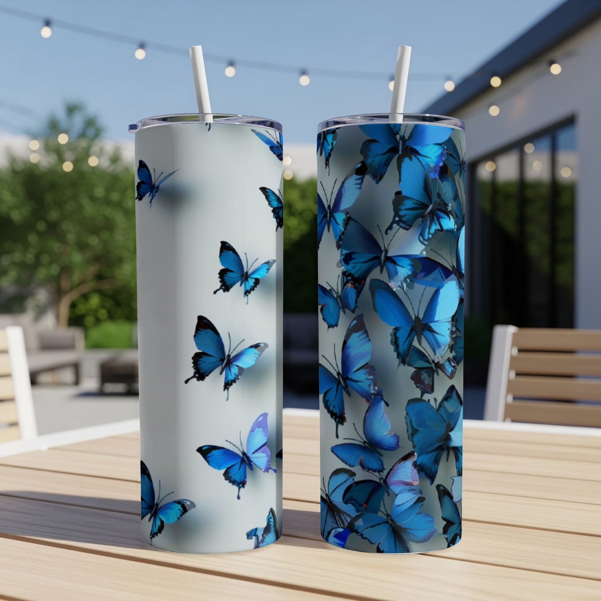 Two tumblers with blue butterfly patterns on a wooden table.