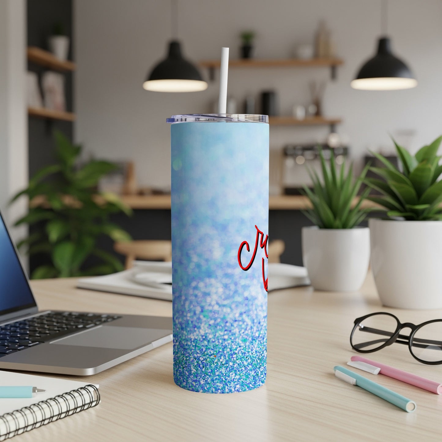 Blue glitter tumbler with red cursive text "Cruz" on a desk.