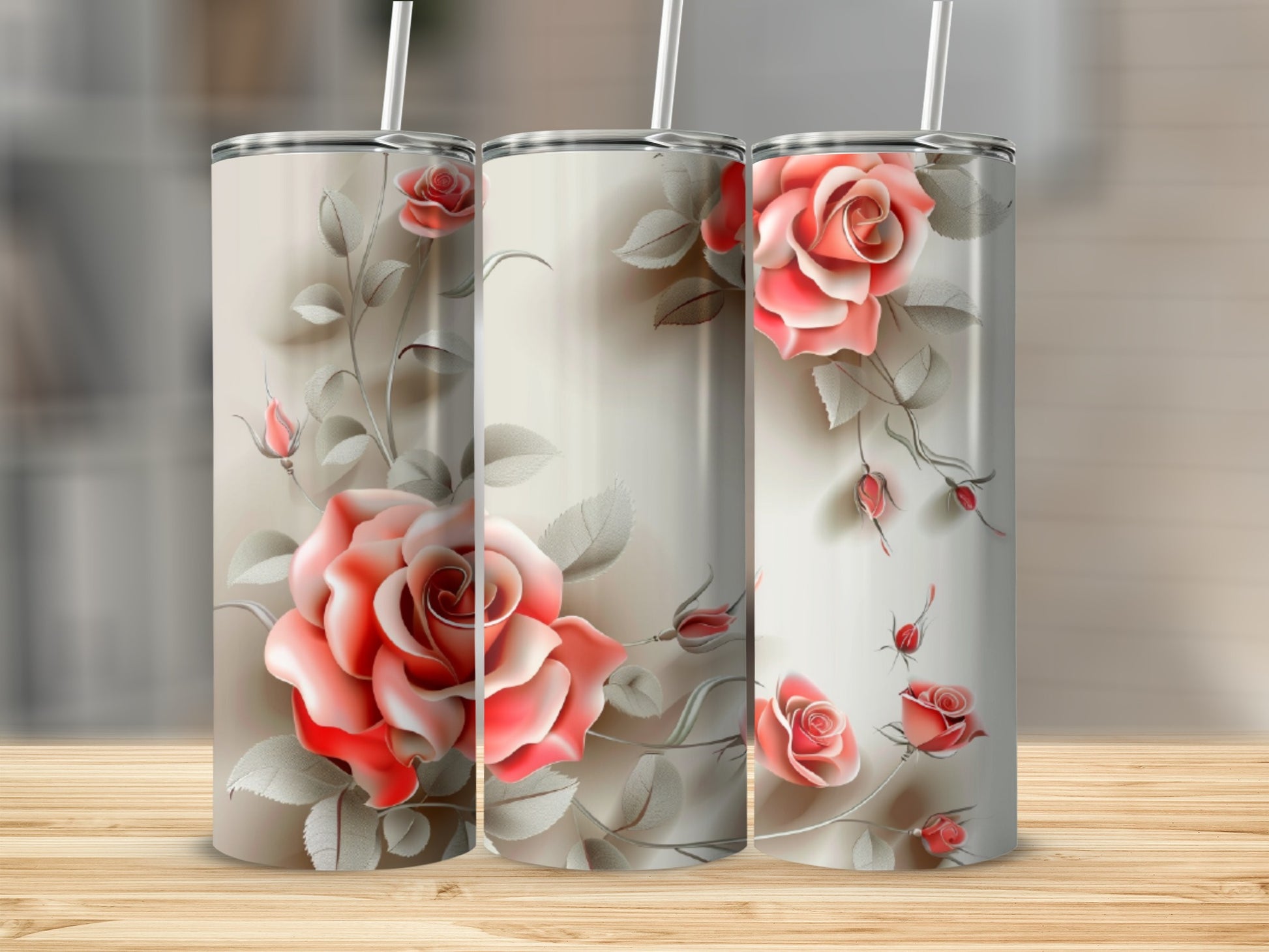 Three tumblers with a coral rose floral design on a wooden surface.