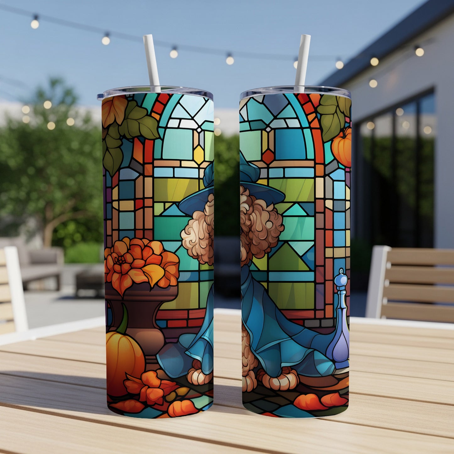 Two tumblers with stained glass design of a witch and pumpkins, outside setting.
