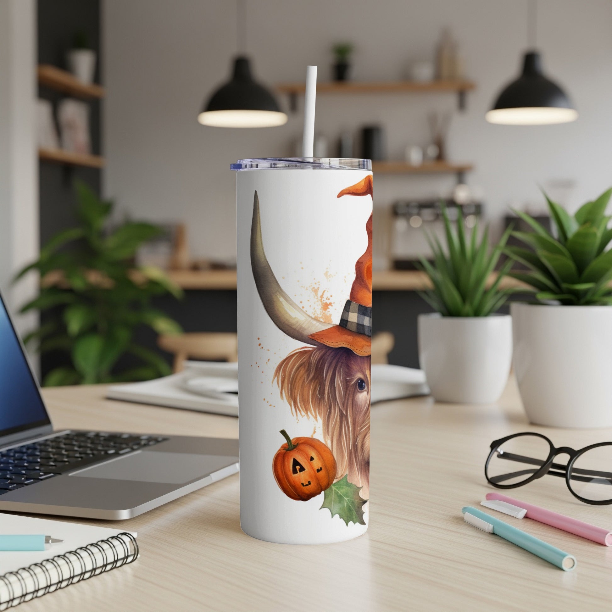 Highland cow in witch hat with pumpkin on tumbler.