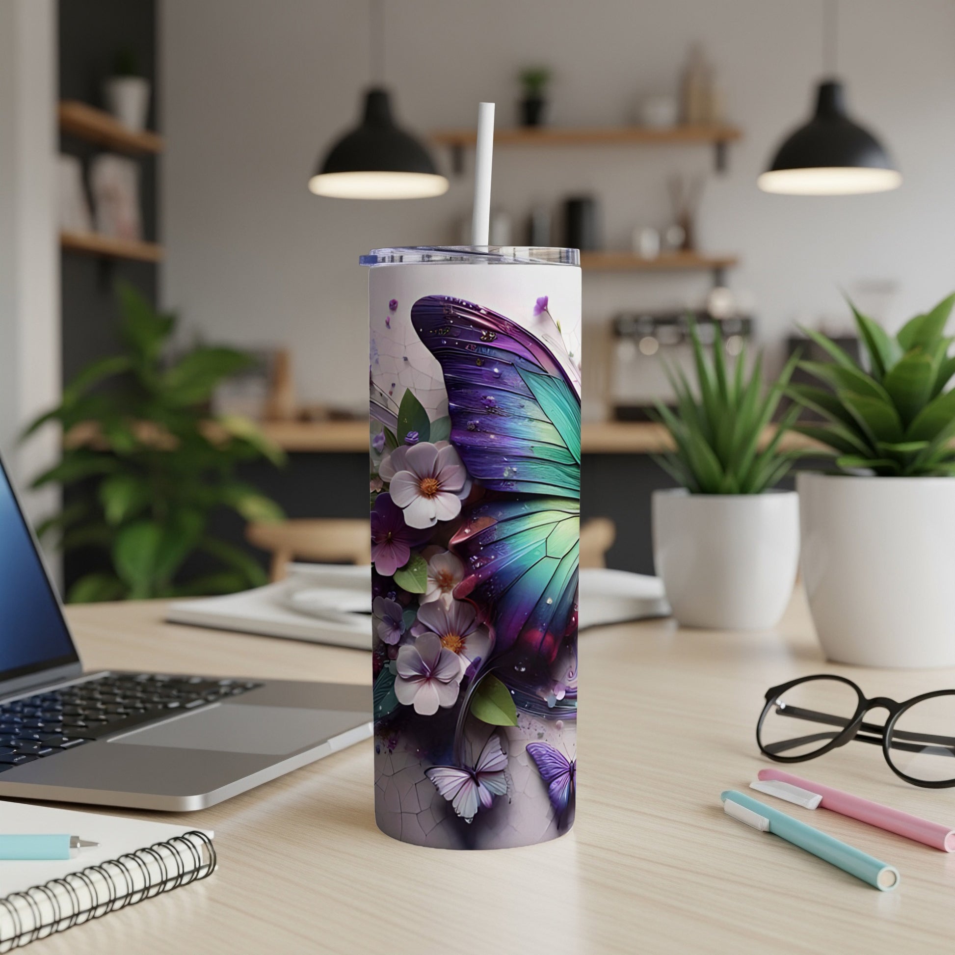 Purple butterfly tumbler with flowers and straw on desk.