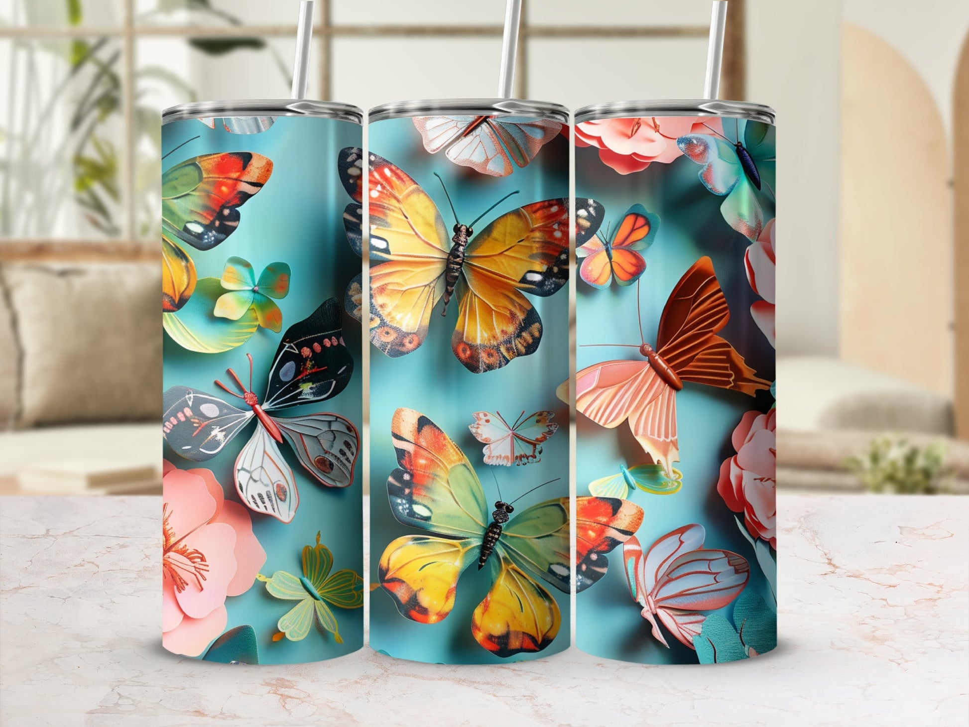 Three tumblers decorated with colorful butterflies and floral designs.