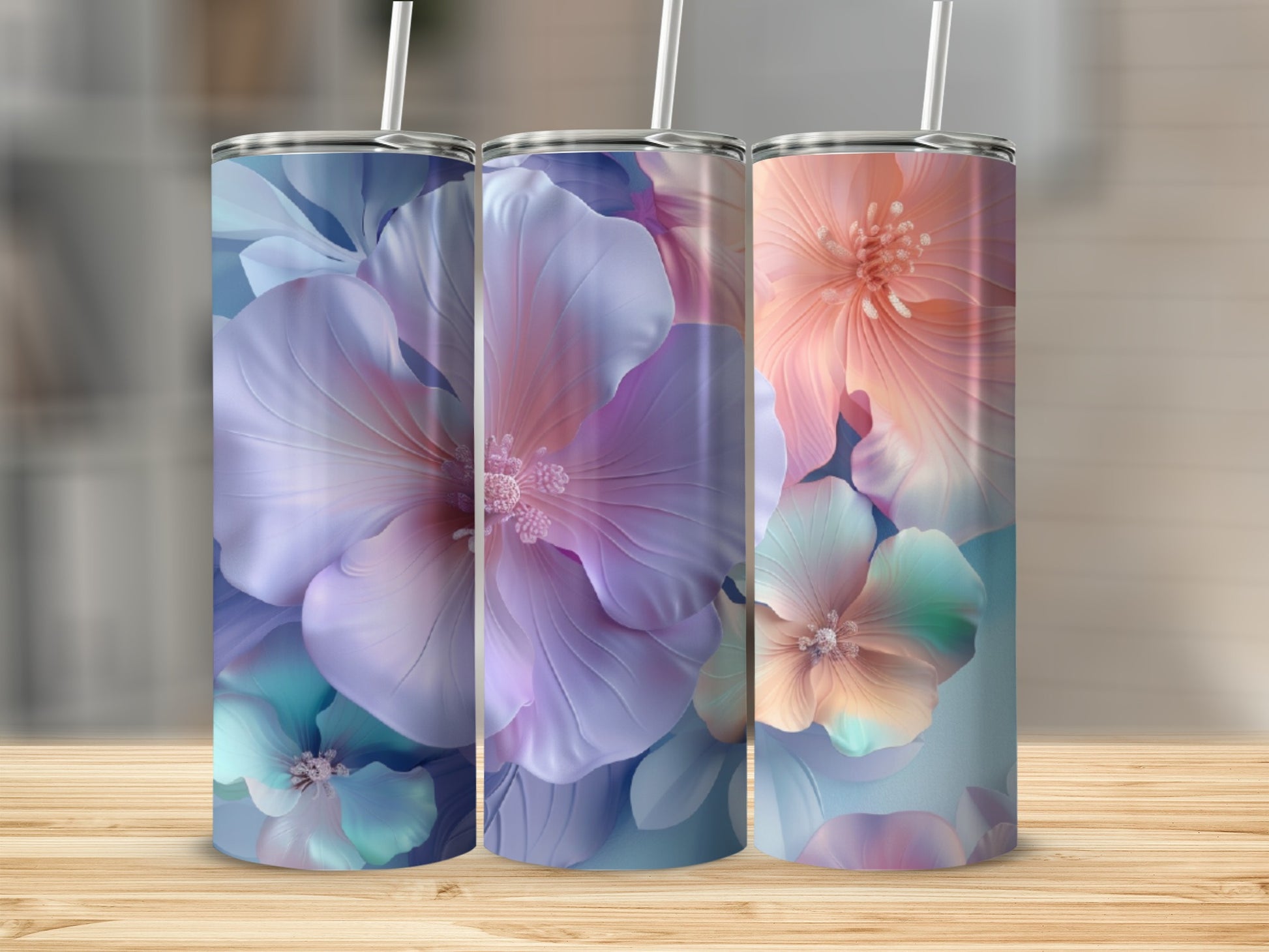 Three tall tumblers with floral designs on a wooden surface.