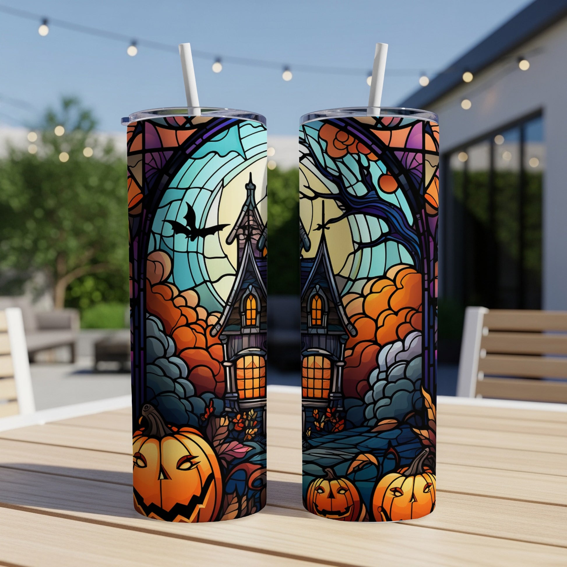 Two tumblers with a stained-glass Halloween house, pumpkins, and moon scene.
